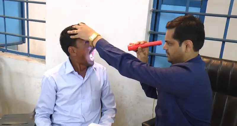 An ophthalmologist examining a patient's eyes at the camp