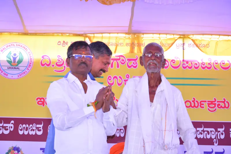 An elderly villager being welcomed at the camp