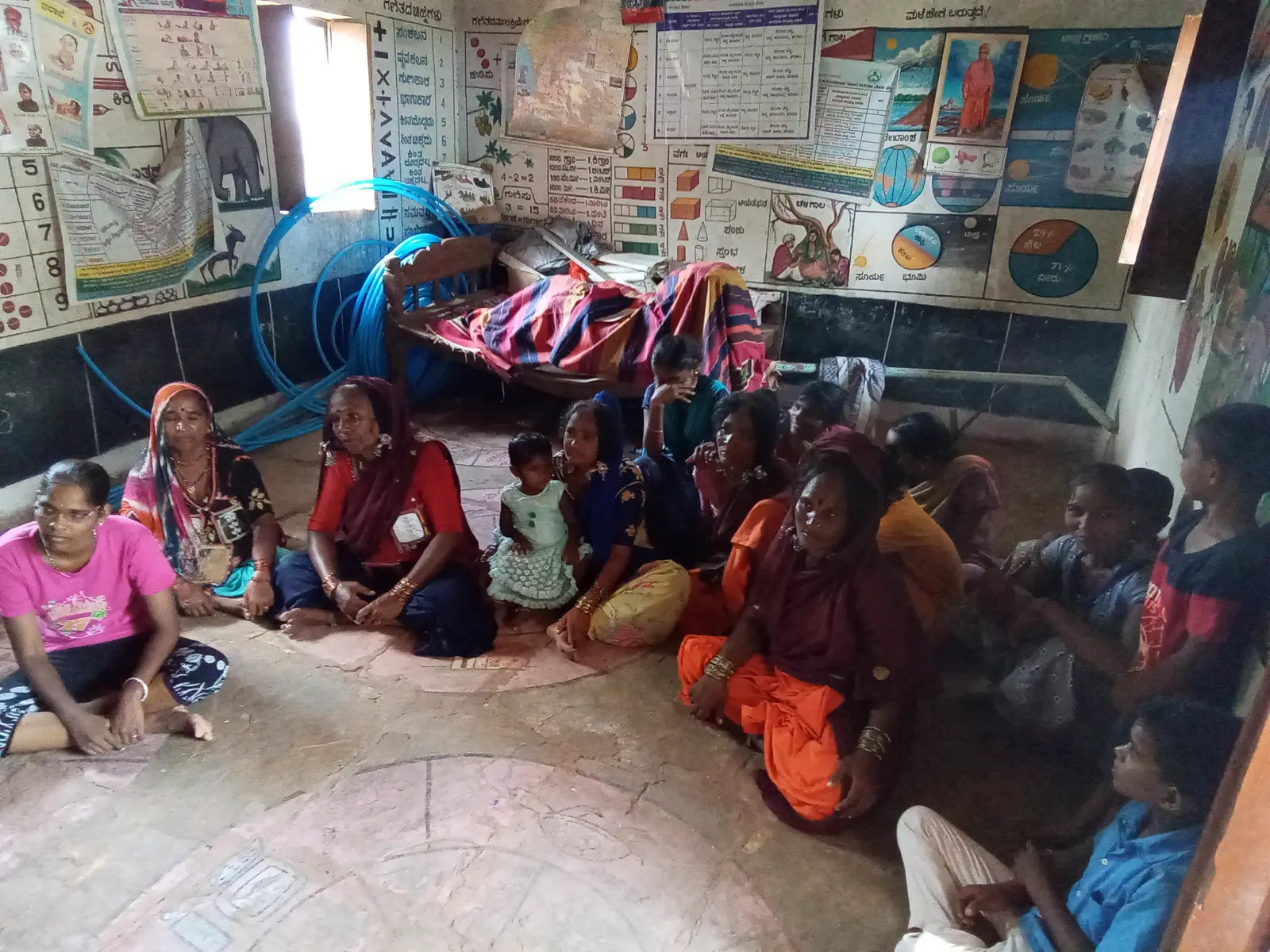 Village women and children seated together at a cancer awareness gathering in a hamlet